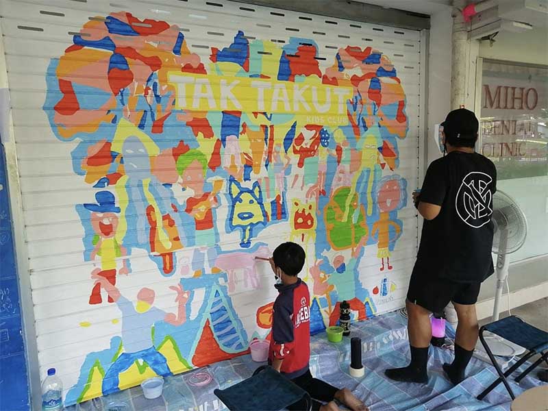 Rizman Putra and a child working